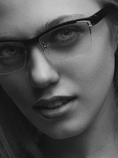 A professional woman wearing glasses in a clinical setting, conveying expertise and approachability, with colors and contrast optimized to remain clear and visually appealing in both light and dark mode